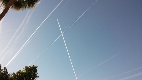 Low angle view of vapor trail against clear blue sky