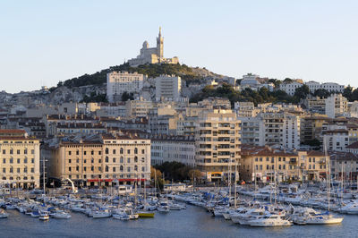 Sailboats in sea against buildings in city