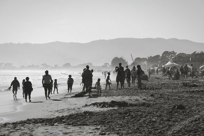 People at beach against sky