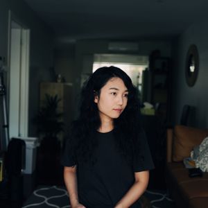 Cute woman looking away while sitting at home