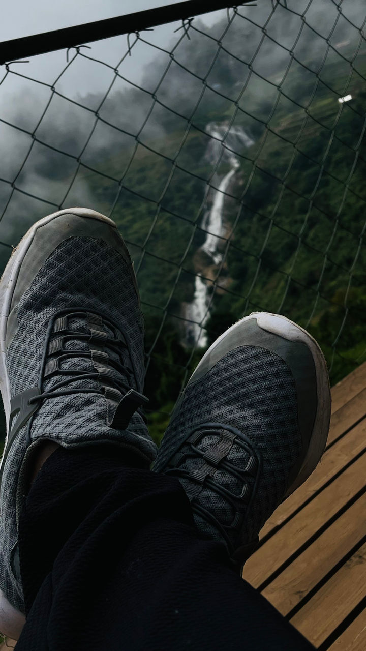 human leg, shoe, low section, personal perspective, one person, black, footwear, limb, lifestyles, human limb, leisure activity, day, human foot, sports, nature, outdoors, standing, men, adult, architecture, high angle view