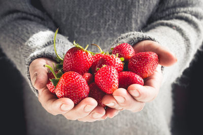 Midsection of woman holding strawberries