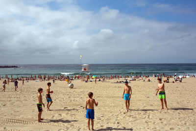 Crowd at beach on sunny day