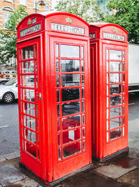 Red telephone booth on street in city