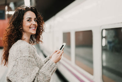 Portrait of smiling young woman using mobile phone