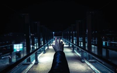Cropped hand reaching railroad station platform at night