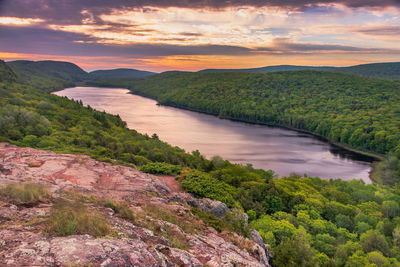 Scenic view of river by mountains against sky