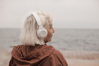 Rear view of woman looking at sea against sky