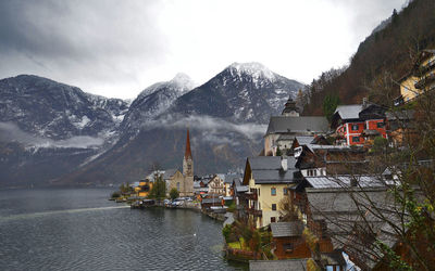 Houses on hill against cloudy sky