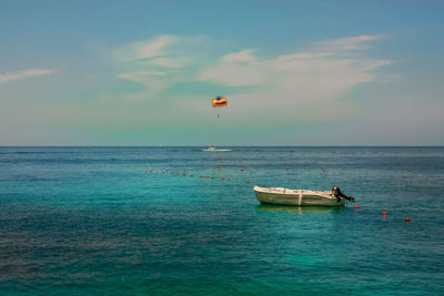 Boat moored on sea against sky