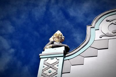 Low angle view of statue against building against sky