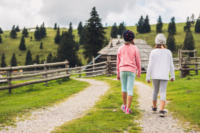 Rear view of women walking on footpath