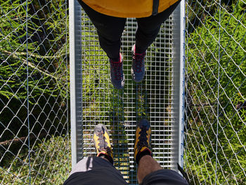 Low section of man standing on fence