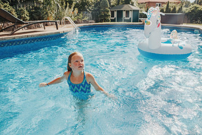 Cute girl standing in swimming pool