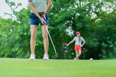 Rear view of man playing with golf course