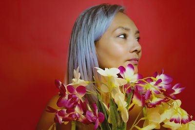 Close-up of woman looking at red flower