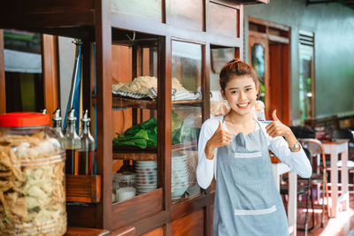 Portrait of smiling young woman standing in store