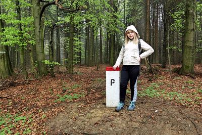 Portrait of young woman standing in forest