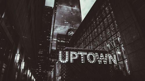 Low angle view of illuminated text on building at night