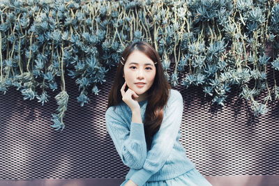 Portrait of young woman sitting outdoors