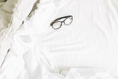High angle view of eyeglasses on bed