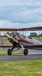 Airplane on airport runway against sky