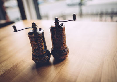 Close-up of antique salt and pepper shakers on table at restaurant