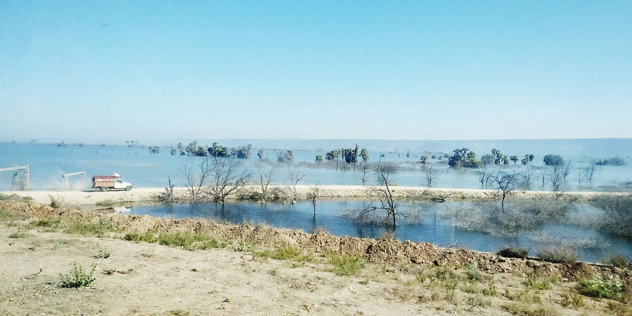 water, shore, sky, sea, nature, beach, scenics - nature, land, clear sky, day, coast, body of water, beauty in nature, horizon over water, tranquility, tranquil scene, horizon, blue, no people, ocean, bay, nautical vessel, transportation, copy space, outdoors, plant, non-urban scene, vacation, sand, sunny, sunlight, mode of transportation, travel, idyllic, travel destinations