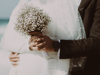 Midsection of couple holding hands