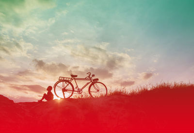 Silhouette bicycle on field against sky during sunset