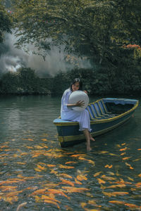Rear view of woman in boat in lake