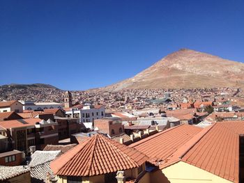 Aerial view of townscape against clear blue sky