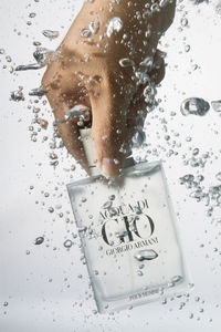 Reflection of man in water splashing in bathroom