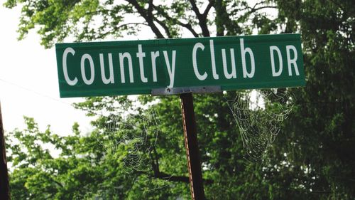 Low angle view of road sign against trees