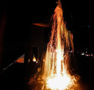 Illuminated bonfire against sky at night