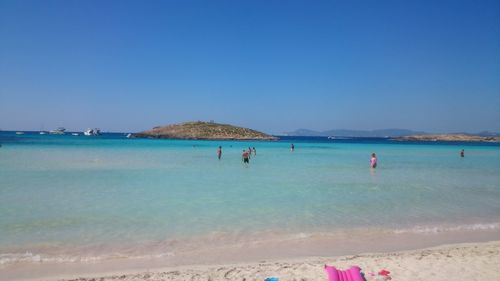 Scenic view of beach against clear blue sky