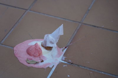 High angle view of pink paper on tiled floor