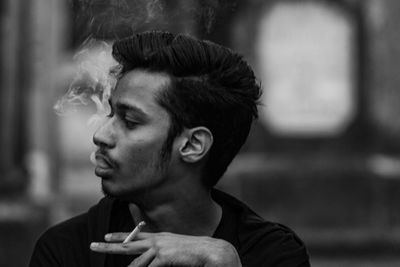 Portrait of young man smoking cigarette