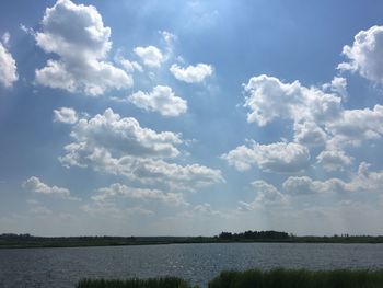 Scenic view of calm lake against cloudy sky