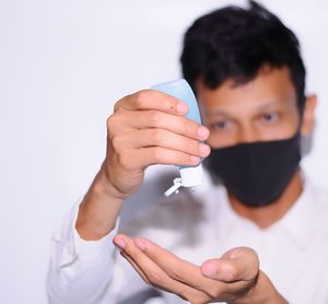 Close-up portrait of young man making face against white background