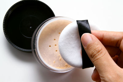 Close-up of hand holding compact powder