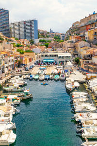 High angle view of boats moored at harbor in city