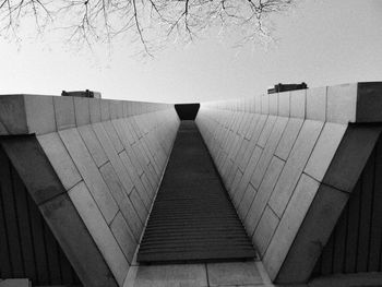 Empty footpath by building against sky