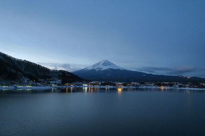 Scenic view of lake and mountains against clear blue sky