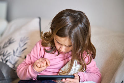 Girl looking away while sitting on mobile phone