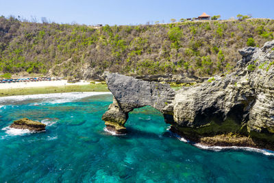 Scenic view of rock formation in sea against sky