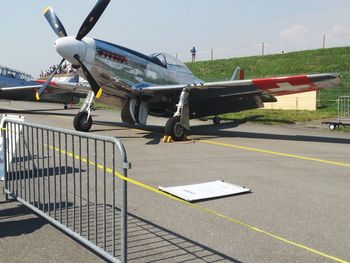 Airplane on airport runway against sky