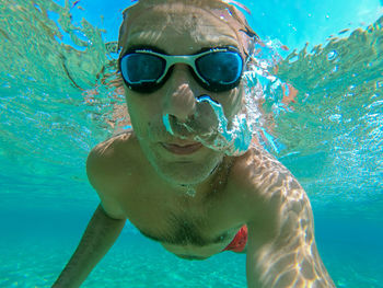 Portrait of shirtless man swimming in pool