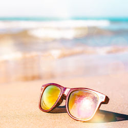 Close-up of sunglasses on beach