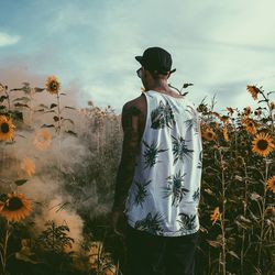 Man standing by plants against sky